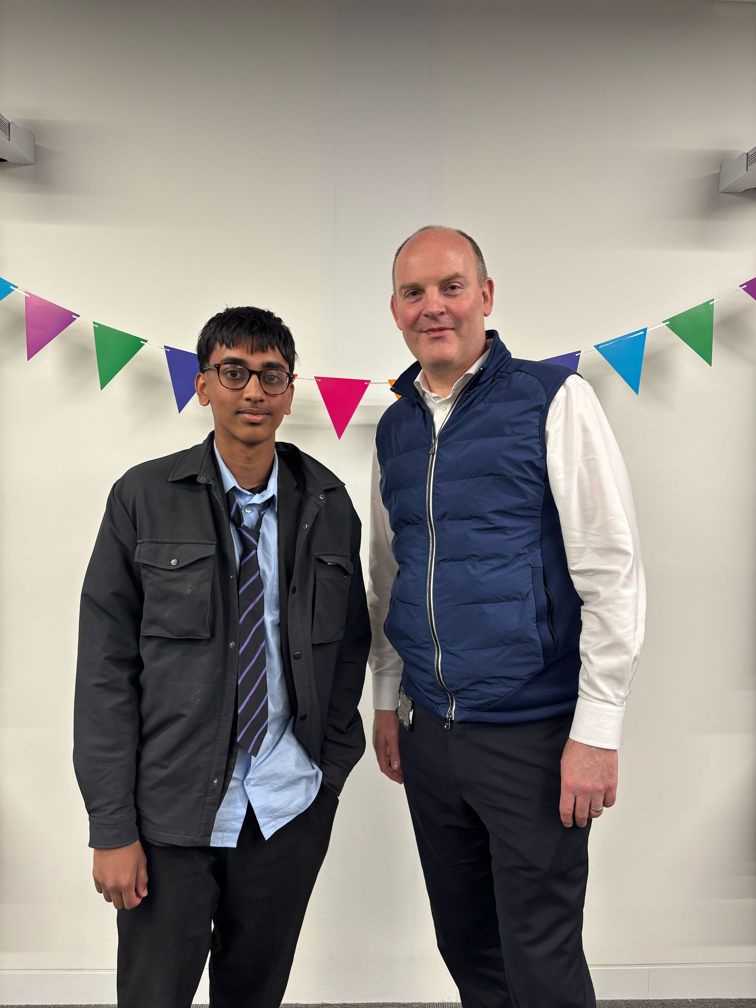 A mentee and a mentor standing next to each other, posing picture, indoors